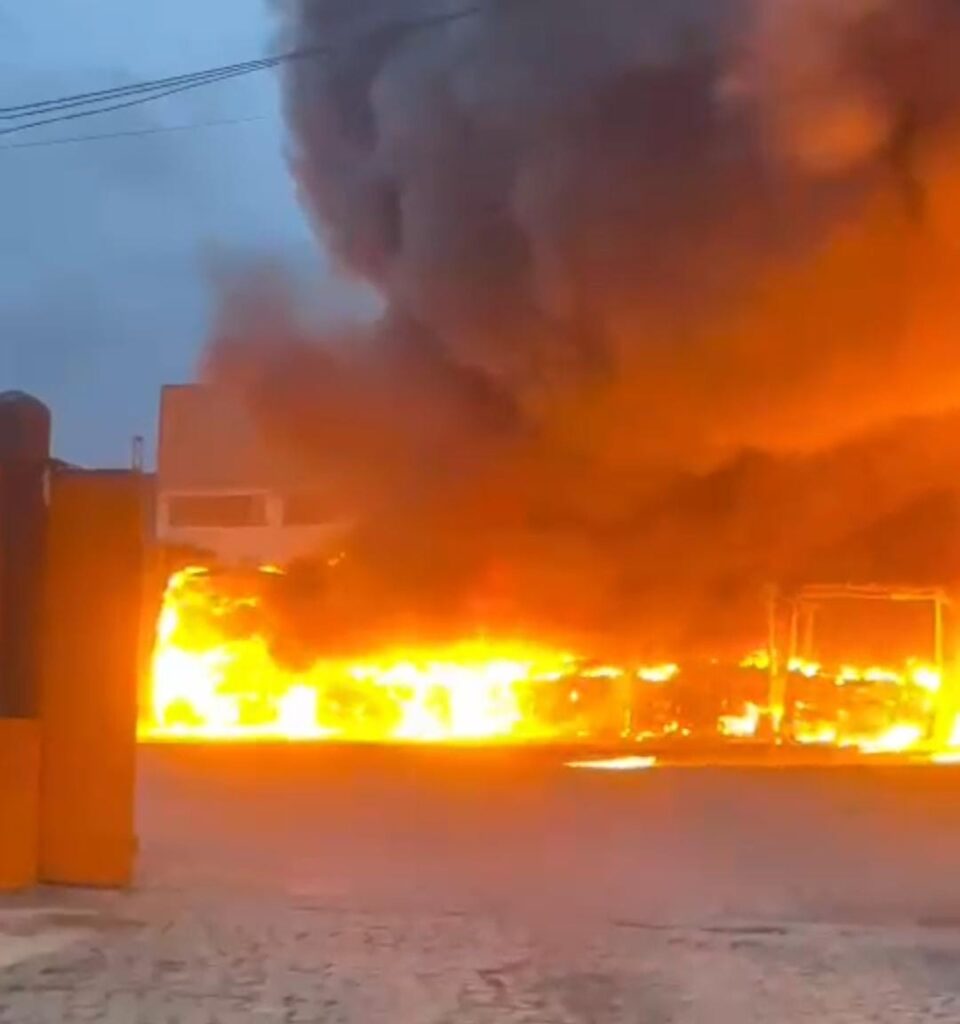 Um ônibus em uma garagem escura com uma placa que diz 'proibido